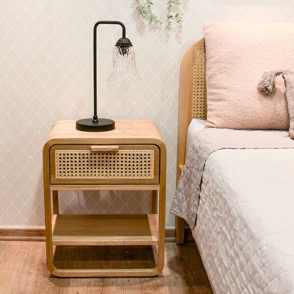 גופי תאורה מעוצבים ליד מיטה עם שידה מעץ, כריות נוי וטפט לקיר. תאורה לחדר שינה נעימה.