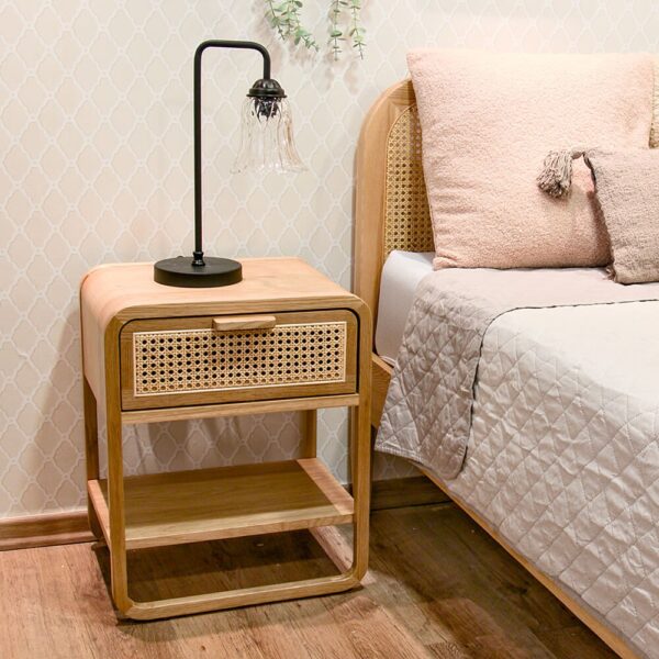 שולחן לילה מעץ עם גופי תאורה מעוצבים וכריות נוי על המיטה, משלים עיצוב מודרני ונעים.