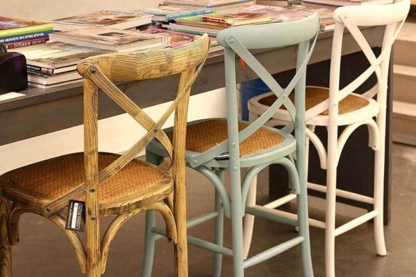 כורסאות מעוצבות בצבעים שונים סביב שולחן עם ספרים, עיצוב מודרני ומיוחד לחלל.