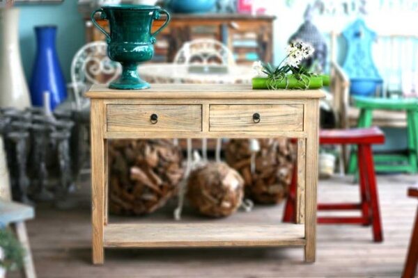קונסולה מעץ עם שני drawers, פרחים וקישוטים, ברקע ריהוט צבעוני ועיצובים שונים.