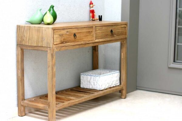 קונסולה מעץ עם שני drawers, מונחת ליד קיר, עם פריטים מעוצבים על השולחן התחתון.